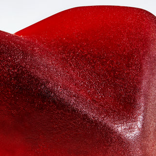 Macro image of the Camino Midnight Blueberry Gummy, it is red with squared off diamond shape and has a matte shine.